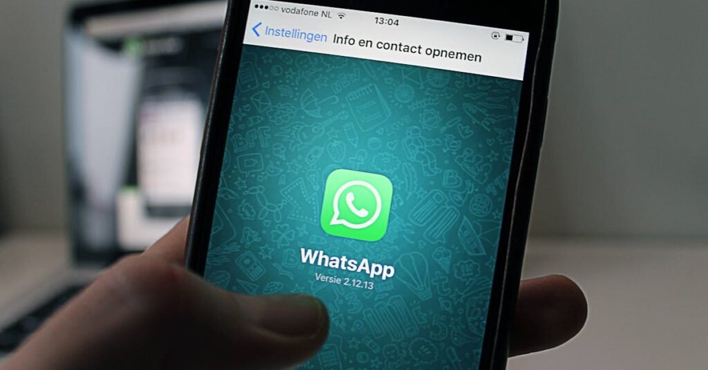 A smartphone displaying the WhatsApp application screen held by a person.